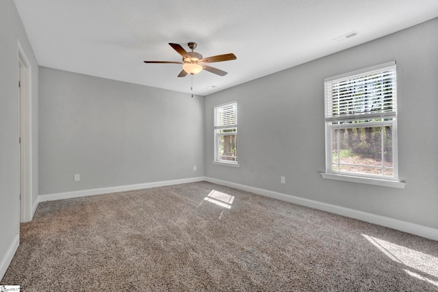 spare room with carpet, visible vents, baseboards, and a ceiling fan