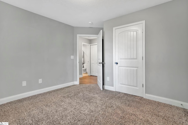 unfurnished bedroom featuring a closet, baseboards, and carpet flooring