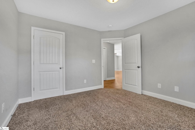 unfurnished bedroom featuring carpet flooring and baseboards
