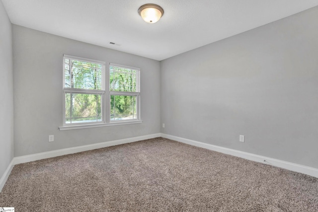 carpeted empty room with baseboards and visible vents