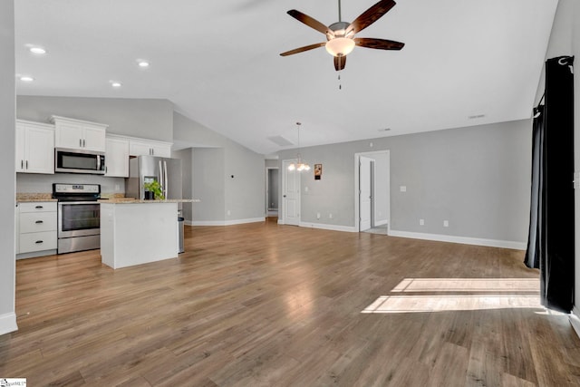 kitchen featuring open floor plan, ceiling fan, a kitchen island, and stainless steel appliances