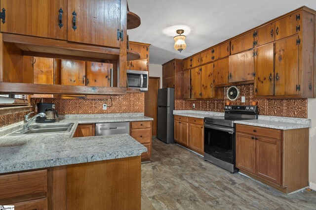 1020 Woodburn Rd, Spartanburg, SC 29302 - kitchen featuring light countertops, backsplash, brown cabinets, appliances with stainless steel finishes, and a sink