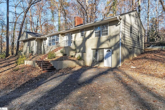 1020 Woodburn Rd, Spartanburg, SC 29302 - rear view of property with stairs, brick siding, board and batten siding, and a chimney
