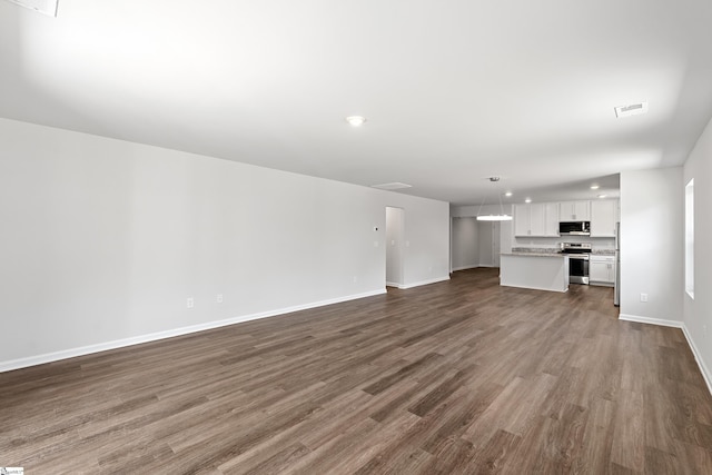 unfurnished living room with recessed lighting, visible vents, baseboards, and dark wood-style floors