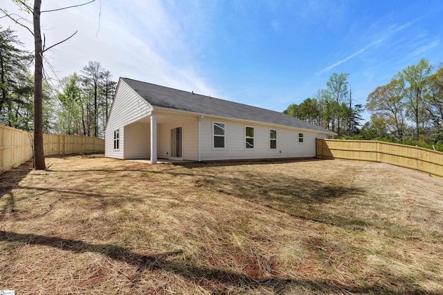 rear view of property featuring a fenced backyard