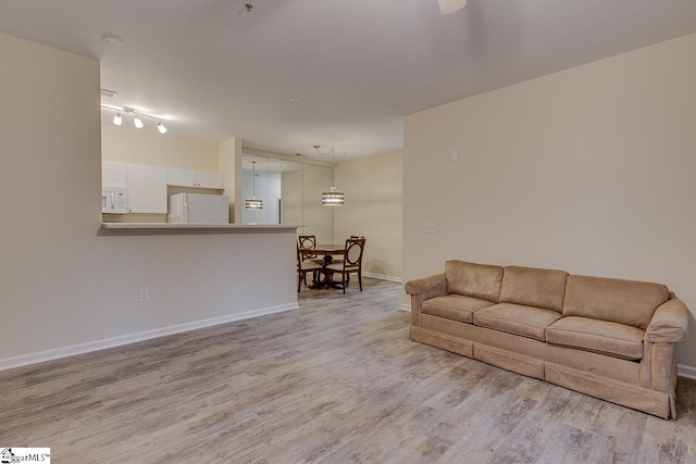 living room with baseboards and light wood-type flooring
