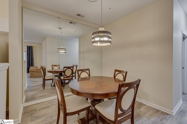 dining room with visible vents, baseboards, and light wood-style floors