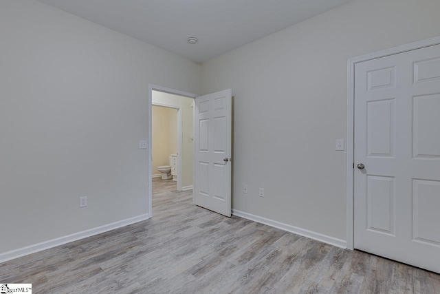 unfurnished bedroom featuring baseboards and wood finished floors