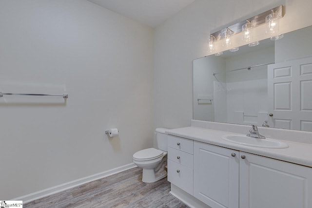 bathroom with vanity, baseboards, toilet, and wood finished floors