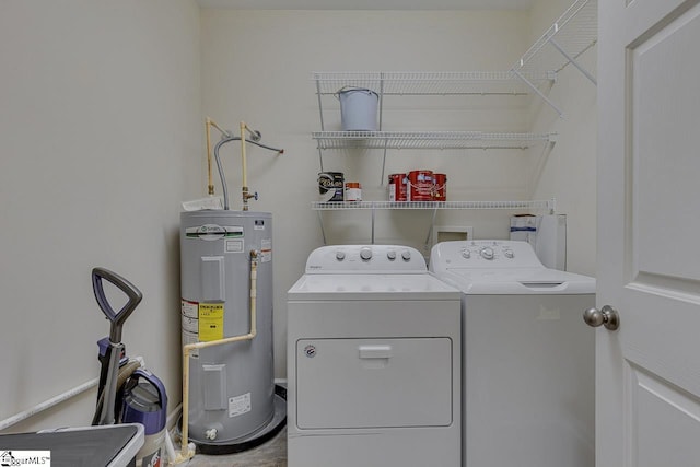 laundry room featuring water heater, separate washer and dryer, and laundry area