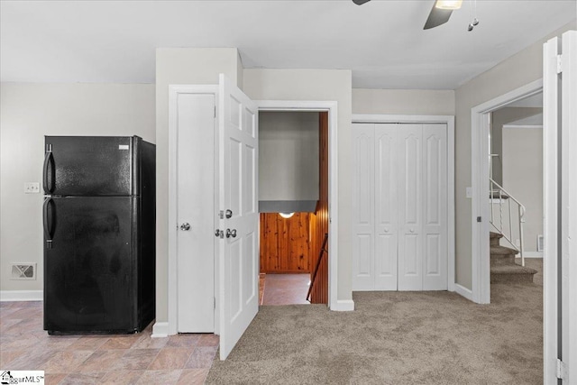 unfurnished bedroom featuring ceiling fan, freestanding refrigerator, light colored carpet, visible vents, and baseboards