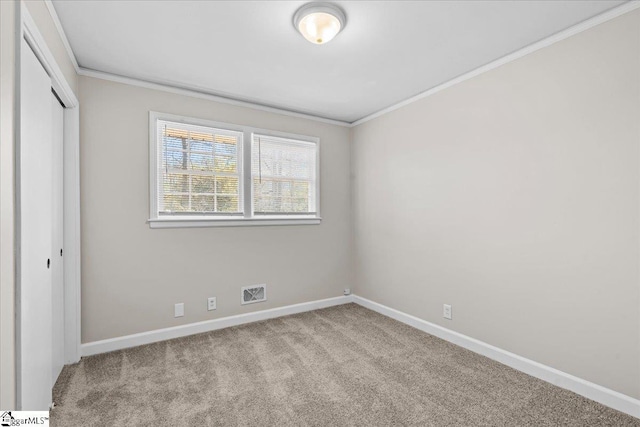 unfurnished bedroom with visible vents, baseboards, ornamental molding, and carpet