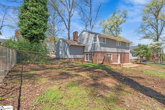rear view of property featuring brick siding and a fenced backyard