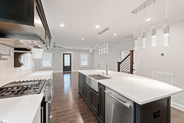 kitchen with visible vents, a sink, ornamental molding, open floor plan, and stainless steel appliances