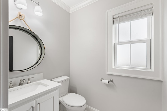 half bathroom featuring toilet, vanity, baseboards, and ornamental molding