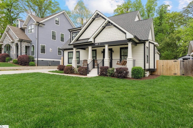 craftsman-style house featuring a gate, a front lawn, a porch, fence, and a shingled roof