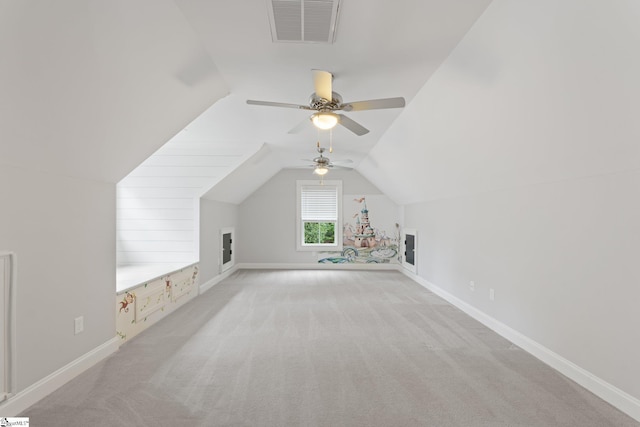 additional living space featuring visible vents, ceiling fan, vaulted ceiling, and light carpet