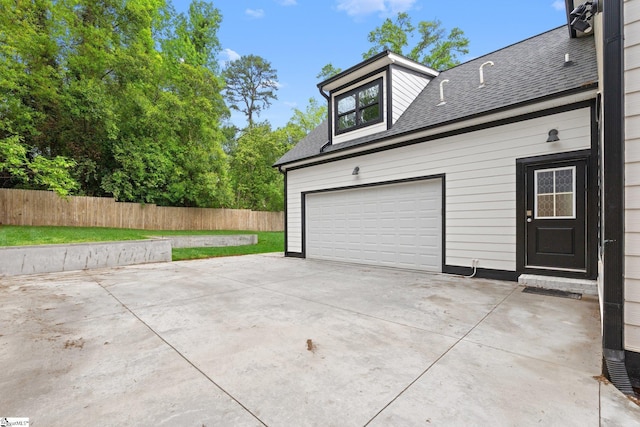 garage with driveway and fence
