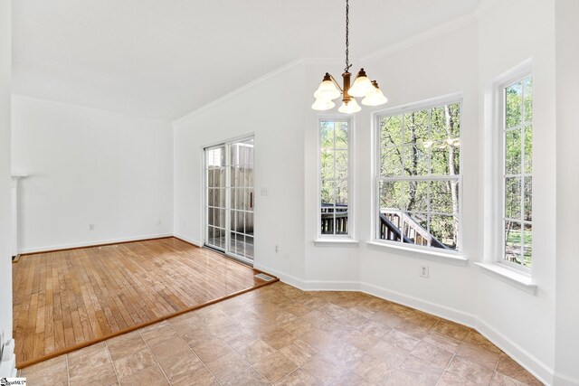unfurnished dining area with crown molding, a healthy amount of sunlight, and a notable chandelier