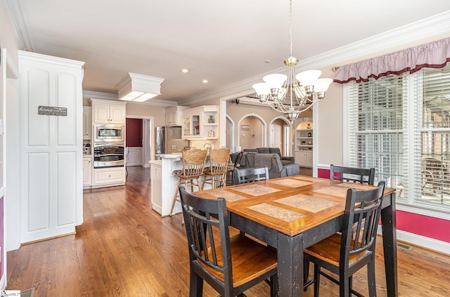 dining room featuring baseboards, ornamental molding, a chandelier, light wood finished floors, and recessed lighting
