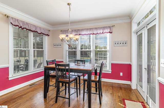dining space with baseboards, ornamental molding, a chandelier, a wealth of natural light, and visible vents