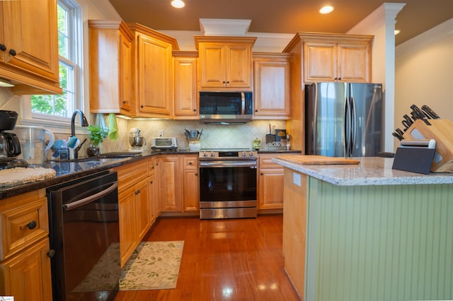kitchen featuring dark wood-style flooring, a sink, recessed lighting, stainless steel appliances, and light stone counters