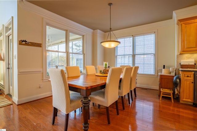 dining room featuring wood finished floors, baseboards, and plenty of natural light
