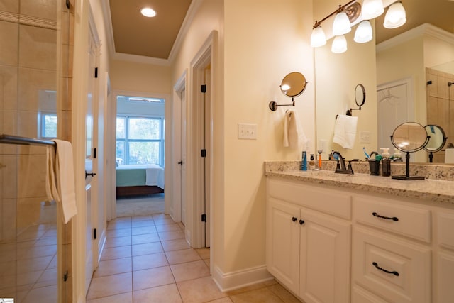 ensuite bathroom featuring vanity, baseboards, ornamental molding, tile patterned flooring, and a tile shower