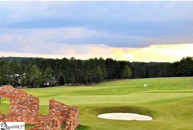 surrounding community featuring golf course view and a lawn
