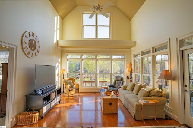 living room with wood-type flooring, high vaulted ceiling, and a ceiling fan