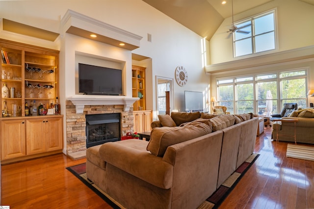 living room featuring high vaulted ceiling, a fireplace, dark wood-type flooring, and ceiling fan