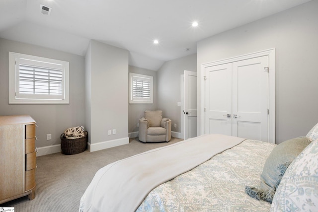bedroom with visible vents, baseboards, a closet, carpet flooring, and lofted ceiling