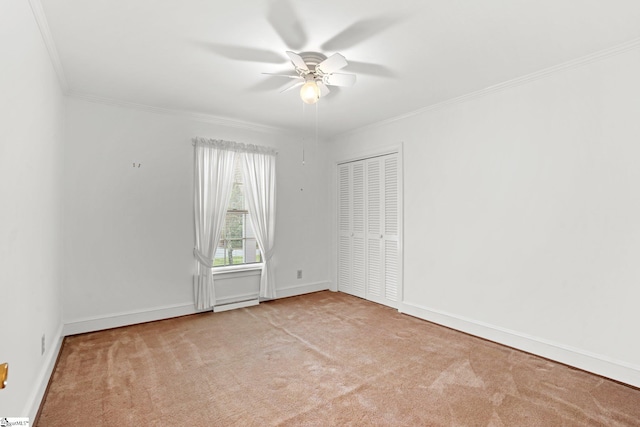 spare room with ornamental molding, ceiling fan, carpet, and baseboards