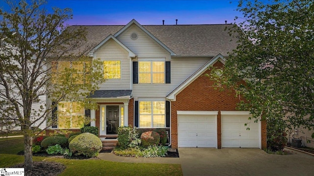 traditional-style house featuring brick siding, roof with shingles, and concrete driveway