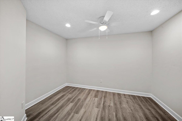 empty room with ceiling fan, baseboards, a textured ceiling, and wood finished floors