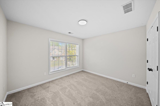 unfurnished room with baseboards, carpet, and visible vents