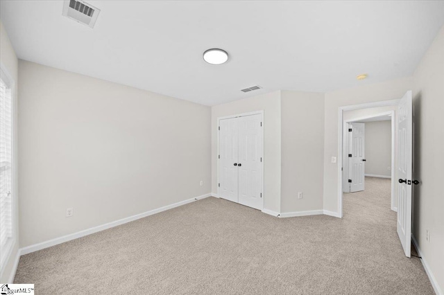 unfurnished bedroom featuring visible vents, baseboards, and light colored carpet