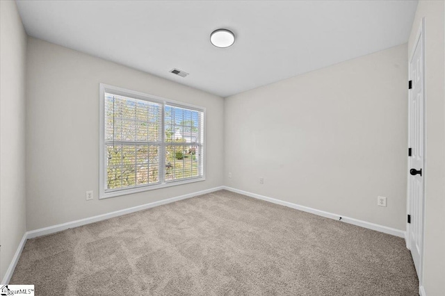 carpeted empty room featuring visible vents and baseboards