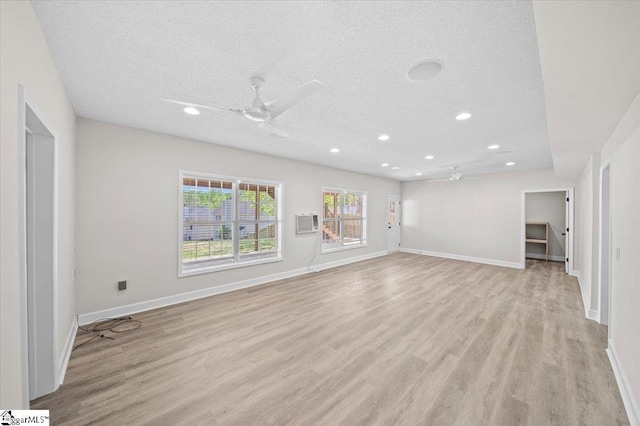 unfurnished living room with light wood-type flooring, a ceiling fan, recessed lighting, and a textured ceiling