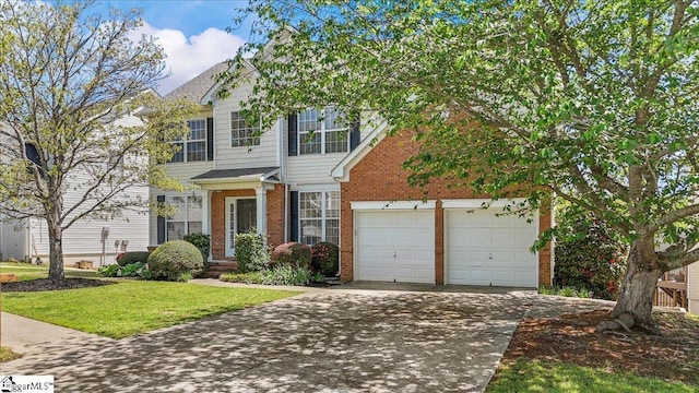 traditional home with concrete driveway, a front yard, brick siding, and a garage