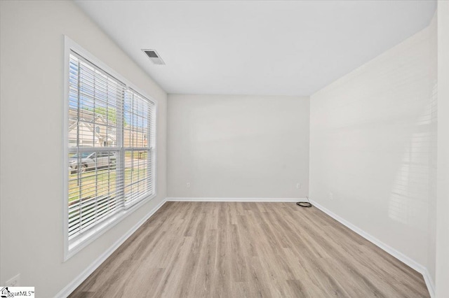 spare room with visible vents, baseboards, and light wood-type flooring