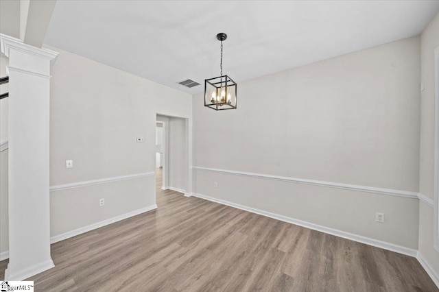 unfurnished dining area featuring an inviting chandelier, light wood finished floors, and visible vents