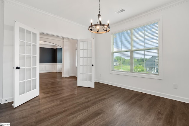 unfurnished dining area featuring an inviting chandelier, french doors, crown molding, visible vents, and arched walkways