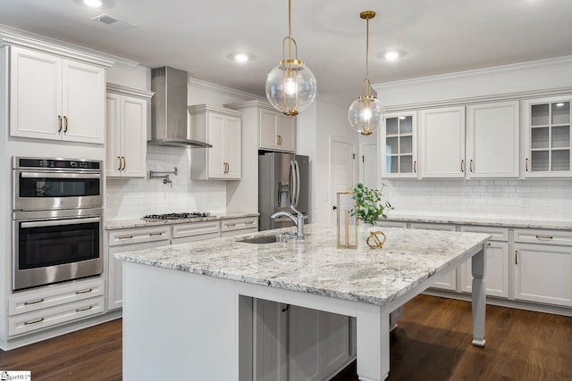 kitchen with wall chimney range hood, backsplash, visible vents, stainless steel appliances, and a sink