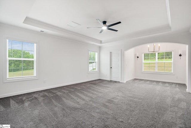 empty room with arched walkways, a tray ceiling, crown molding, and ceiling fan with notable chandelier