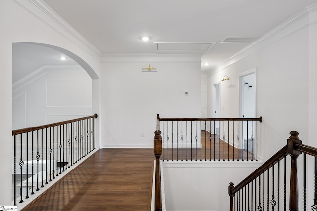 hallway featuring wood finished floors, attic access, ornamental molding, and an upstairs landing