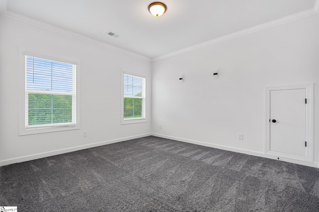 unfurnished room with baseboards, dark carpet, visible vents, and crown molding