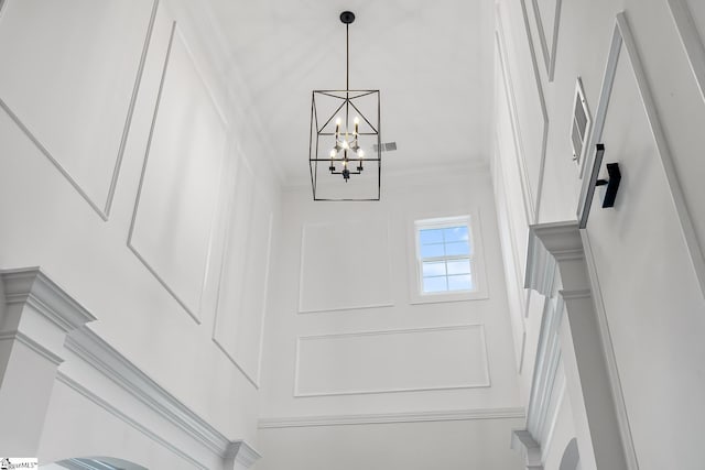 interior details featuring crown molding and an inviting chandelier