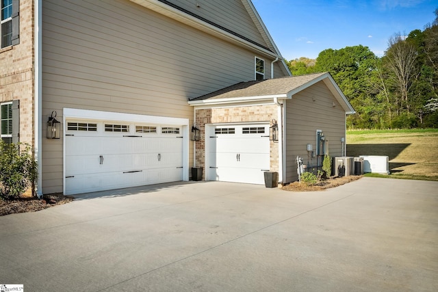 view of side of property with driveway and a shingled roof