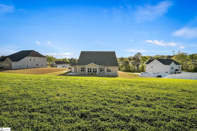 back of house featuring fence and a lawn